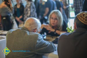 A woman speaks to a Holocaust survivor at the 2018 Yom HaShoa event.