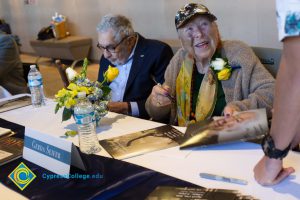 Holocaust survivor Gerda Seifer smiles as she signs a book at the 2018 Yom HaShoah event.