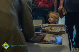 A young girl looks on as programs are being signed,