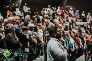 Audience at the Yom HaShoah event standing for the Pledge of Allegiance.