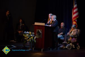 Two women at the podium while others look on during the 2018 Yom HaShoah event.