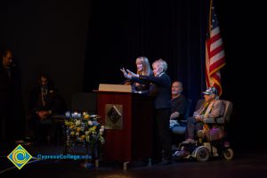 Two women at the podium while others look on during the 2018 Yom HaShoah event.