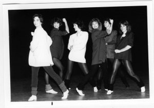 Vintage black and white photo showing the 80s clothing style of leggings, leg warmers and blazers.