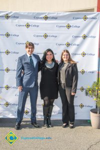 Young man with blue suit and tie with his arm around a young woman with glasses and long brown hair with Yanet Garcia.