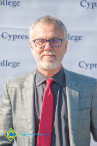 Man in suit, red tie and glasses.