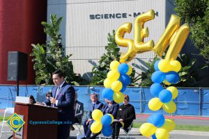 Man in a blue suit speaking to audience at the SEM Groundbreaking ceremony.