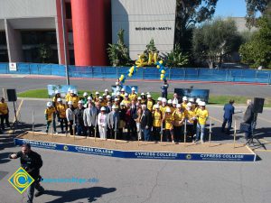 Group of people standing near shovels and dirt display box during SEM Groundbreaking ceremony.