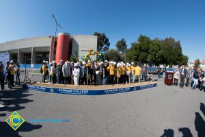 Group of people standing near shovels and dirt display box during SEM Groundbreaking ceremony.