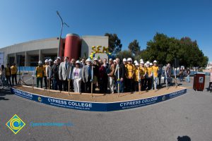 Group of people standing near shovels and dirt display box during SEM Groundbreaking ceremony.