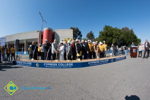 Group of people standing near shovels and dirt display box during SEM Groundbreaking ceremony.