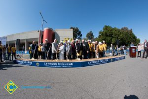 Group of people standing near shovels and dirt display box during SEM Groundbreaking ceremony.