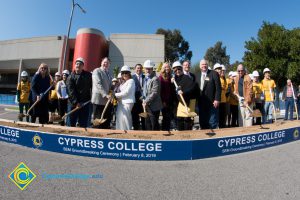 Group of people standing near shovels and dirt display box during SEM Groundbreaking ceremony.