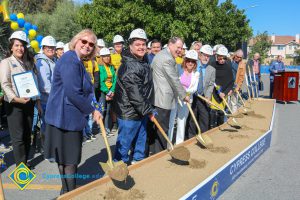 Group of people standing near shovels and dirt display box during SEM Groundbreaking ceremony.