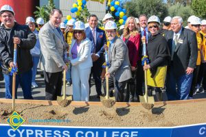 Group of people standing near shovels and dirt display box during SEM Groundbreaking ceremony.