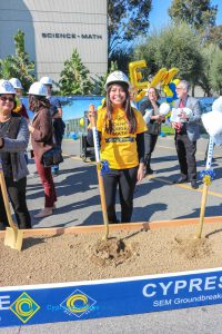 Group of people standing near shovels and dirt display box during SEM Groundbreaking ceremony.