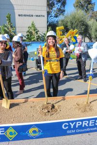 Group of people standing near shovels and dirt display box during SEM Groundbreaking ceremony.