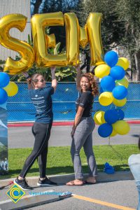 Two young ladies under the SEM balloon arch,