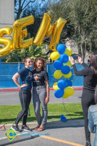 Two young ladies under the SEM balloon arch,