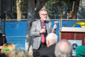 Man in suit, red tie and glasses.