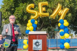 Man in suit and red tie speaking at SEM Groundbreaking ceremony.