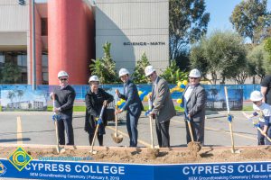 Staff shoveling dirt at the SEM Groundbreaking ceremony.