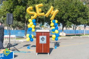 Podium with blue and yellow balloon arch and SEM balloons.