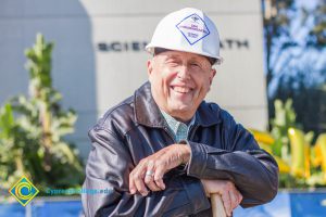 Man in a white hard hat smiling.