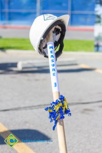 White hard hat on a shovel handle.