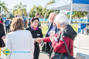 Carmen Dominguez shaking hands with another woman as Dr. Marshall looks on.