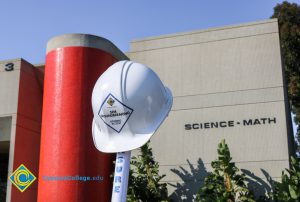 White hard hat on a shovel handle.