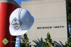 White hard hat on a shovel handle.