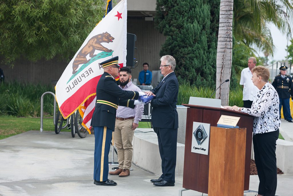 Dr. Simpson receives a flag during the College's 50th Anniversary celebration.