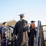 Students being congratulated as they receive their degree during commencement.