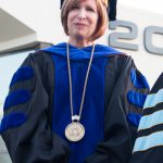 Dr. JoAnna Schilling smiling in her academic regalia during commencement.