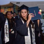 Happy students showing off their degree at commencement.