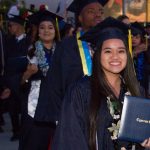 Happy students showing off their degree at commencement.