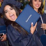 Happy students showing off their degree at commencement.