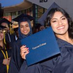 Happy students showing off their degree at commencement.