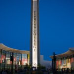 Lit campanile with commencement set up and stage.