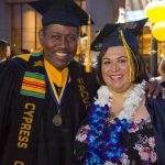 Virgil Adams and a female graduate smiling at commencement.