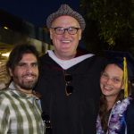 Bryan Seiling with a young graduate and another man who is smiling.