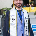 An EOPS graduate smiling at commencement.