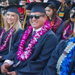 Smiling graduates during commencement ceremony.