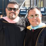 Paul de Dios and Gary Gopar in their academic regalia during commencement.