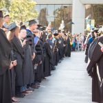 Staff and faculty lined up waiting for graduates to walk through to commencement.