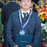 Happy graduate smiling with his degree.