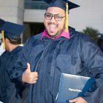 Happy graduate giving a thumbs up.