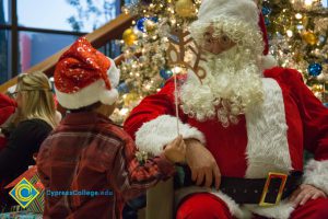 Santa Claus speaking to a young child.