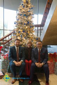 Rick Rams, Dr. JoAnna Schilling and Paul de Dios sitting with a decorated Christmas tree behind them.