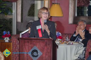 Dr. JoAnna Schilling speaking into a microphone at the 2018 Americana Kickoff.